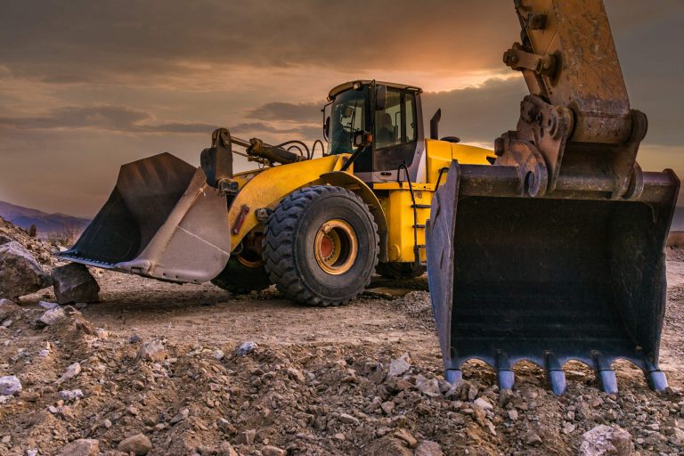 Ein gelber Bagger auf einem Kiesplatz